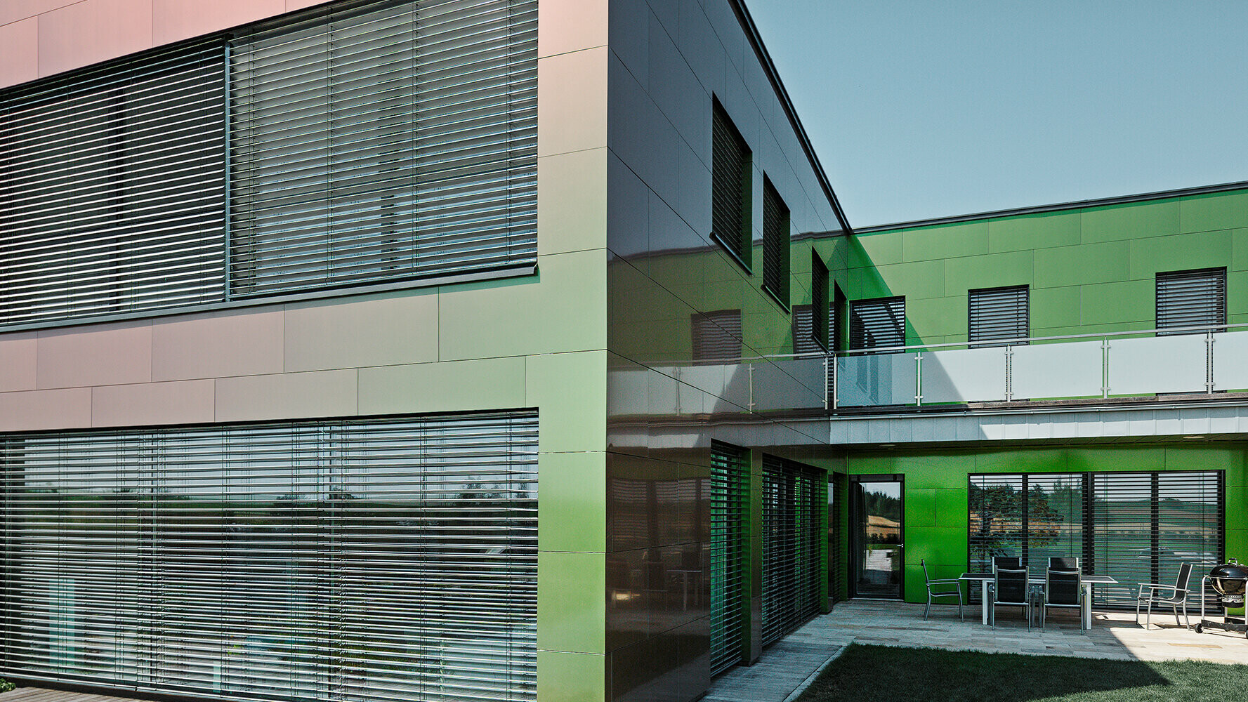La facciata con pannelli compositi di questa abitazione è marrone, verde o viola scuro a seconda della luce e della prospettiva.