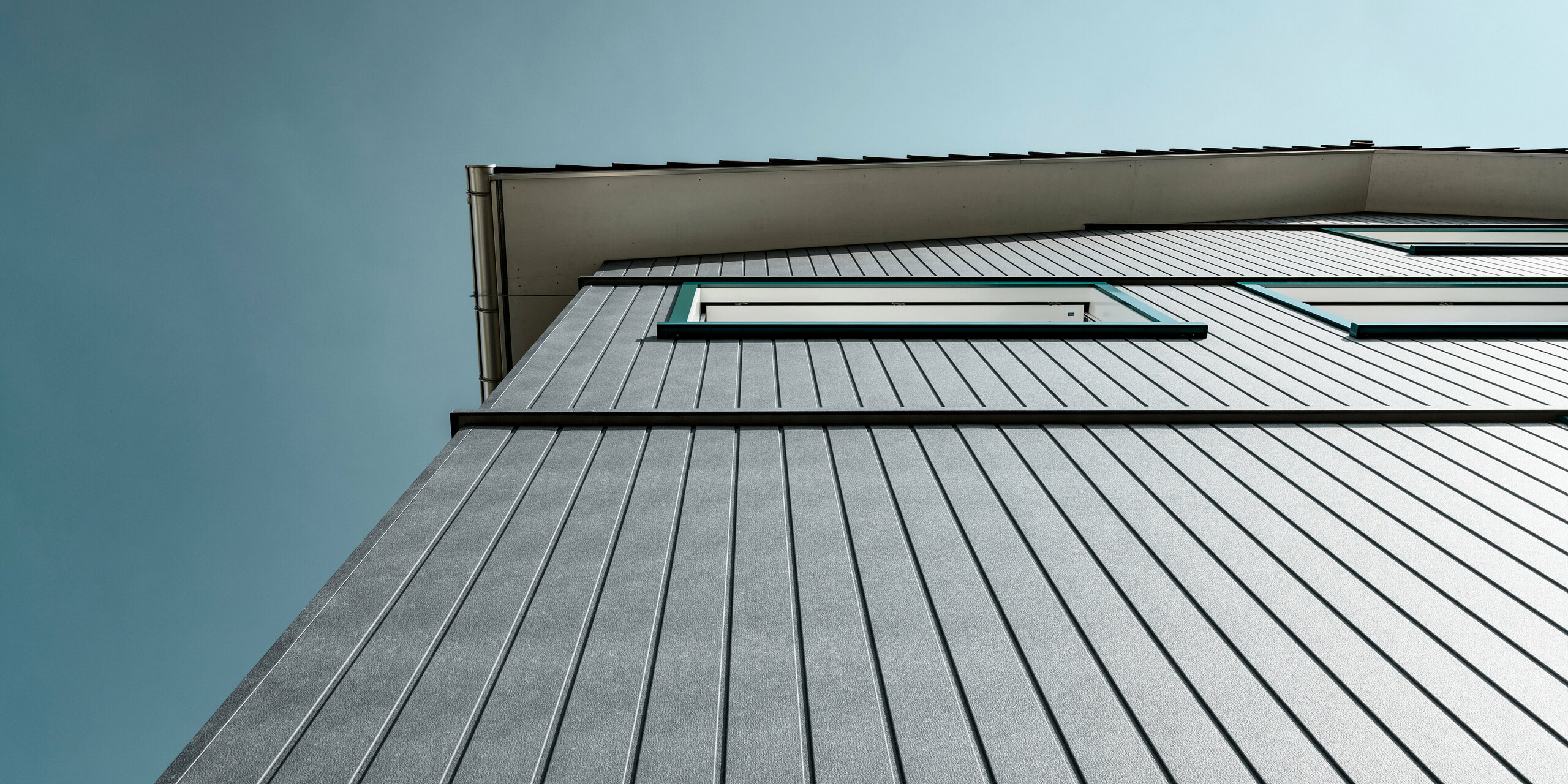 Sidings PREFA en gris pierre P.10 et blanc Prefa P.10 sur les façades de deux immeubles d'habitation voisins à Weissbad, en Suisse.