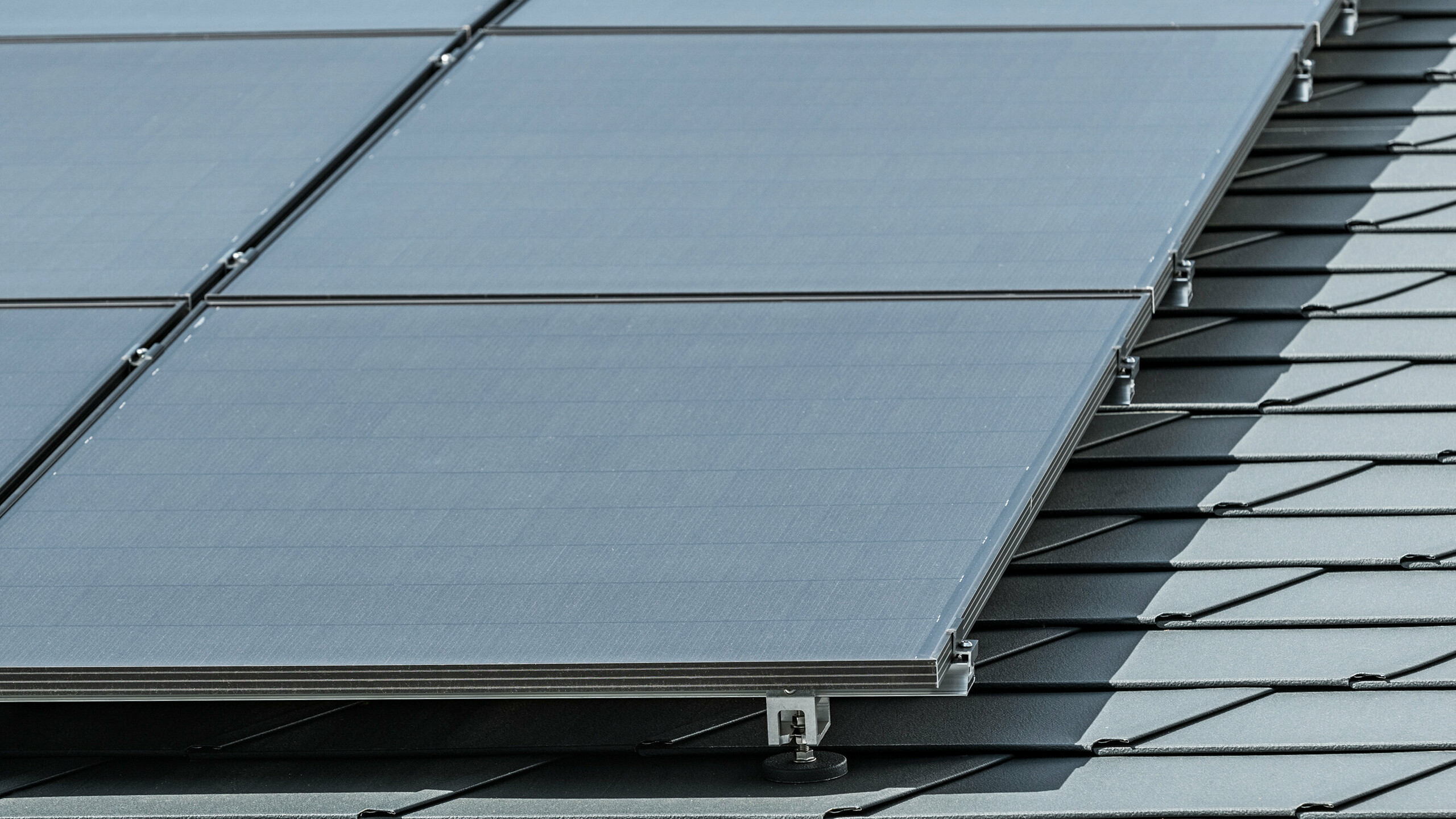 Primo piano di un impianto fotovoltaico montato su scandola DS.19 PREFA in P.10 antracite con PREFA Solar Holder Vario