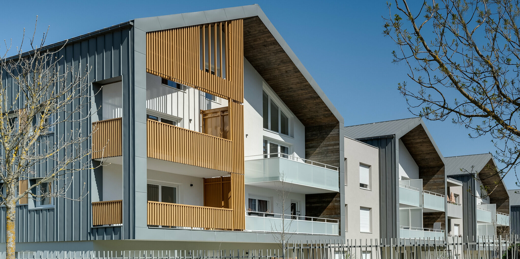 La Résidence L'Athéna se compose de plusieurs parties du bâtiment qui ont été revêtues de PREFALZ en P.10 gris souris. Le complexe résidentiel a été construit par ARCANE Architectes à Varces-Allières-et-Risset, France.