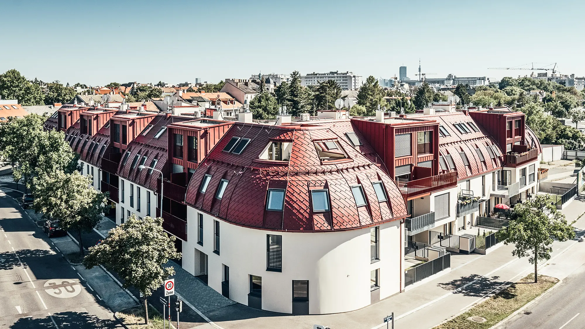 Vista dalla strada del complesso residenziale Schöneck 13 e del tetto arrotondato, progettato dallo studio di architettura schneider+schumacher.