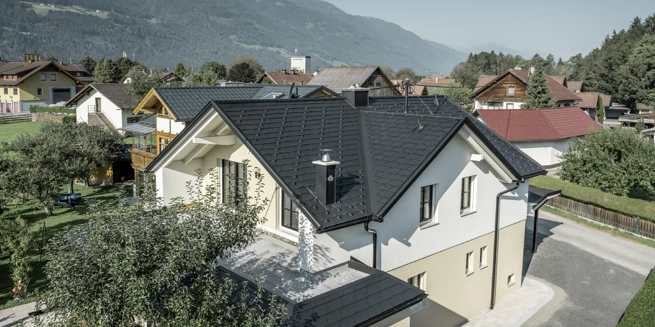 Traditionelles Einfamilienhaus mit Satteldach und großer Gaube, frisch saniert. Das Dach ist mit schwarzen Dachschindeln von PREFA eingedeckt.