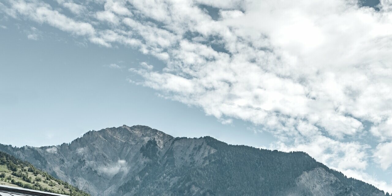 Toiture d’un chalet rustique en Suisse avec façade en bois et toiture en alu de PREFA. Le choix s’est porté sur la tuile R.16 couleur gris pierre. On peut voir la toiture anguleuse et la noue.