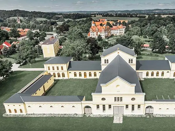 Veduta aerea della Marstall di Basedow, Germania; l’immagine offre un buono sguardo d’insieme dell’edificio con la nuova copertura in scandole PREFA in alluminio color antracite.