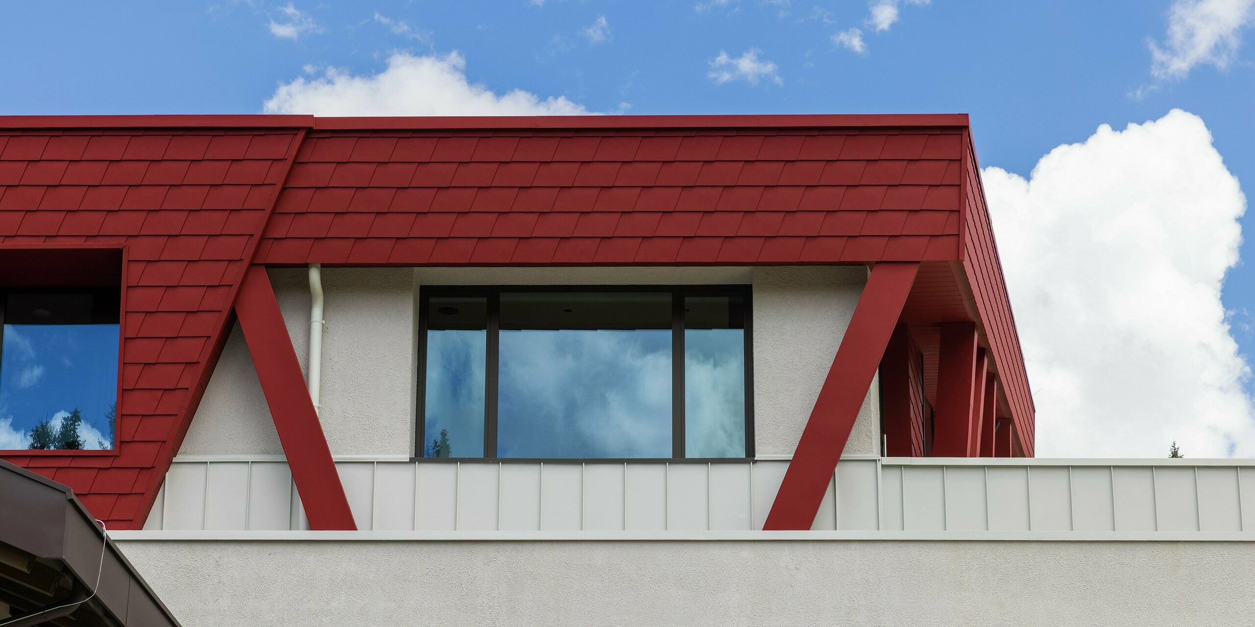 L'enveloppe remarquable du Summit Mountain Club à Ratschings se distingue par sa façade peinte en rouge oxyde P.10. Les bardeaux PREFA, posés avec précision, et une poutre de soutien rouge imposante y sont mis en valeur. Ces matériaux robustes offrent une protection optimale contre les rigueurs du climat montagnard et confèrent au restaurant un design moderne et attrayant.