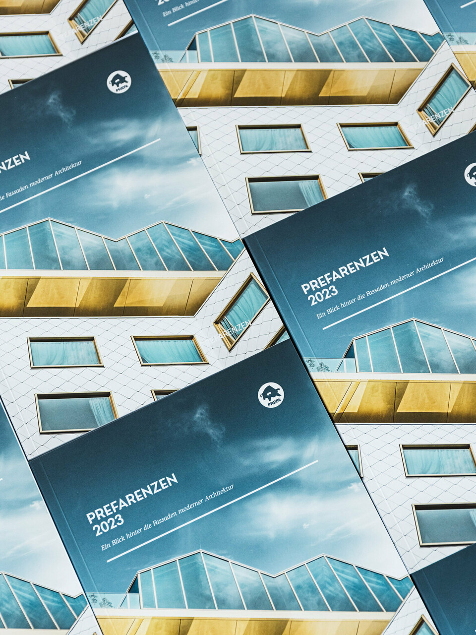 Vue de face de plusieurs livres PREFARENZEN 2023 juxtaposés, ce qui donne une impression d’imbrication.