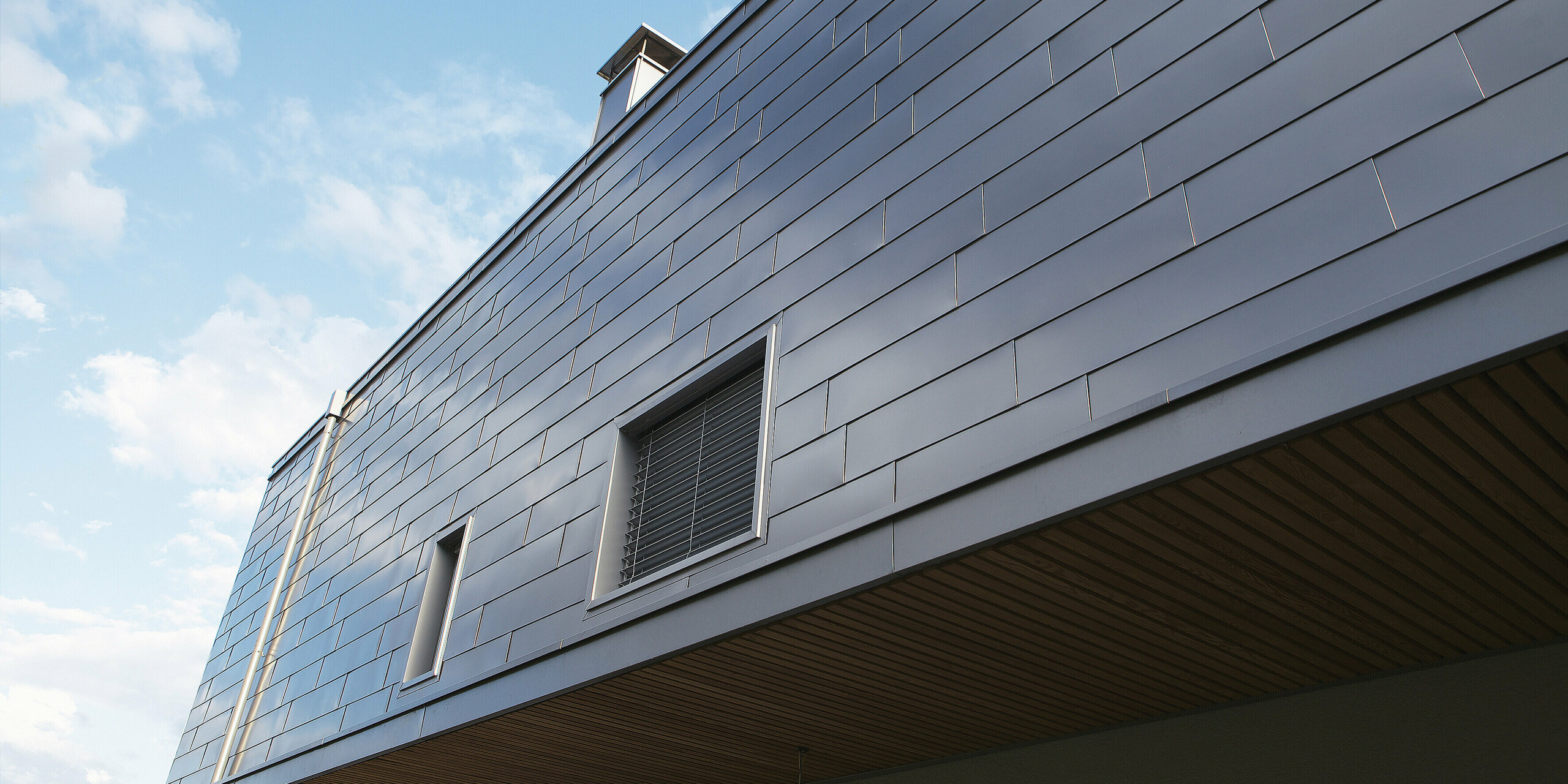Die Detailaufnahme zeigt die hochwertige Verarbeitung der PREFALZ Aluminiumfassade. Die glatte Oberfläche sorgt für ein harmonisches Gesamtbild und bietet gleichzeitig optimalen Schutz gegen extreme Witterungseinflüsse.