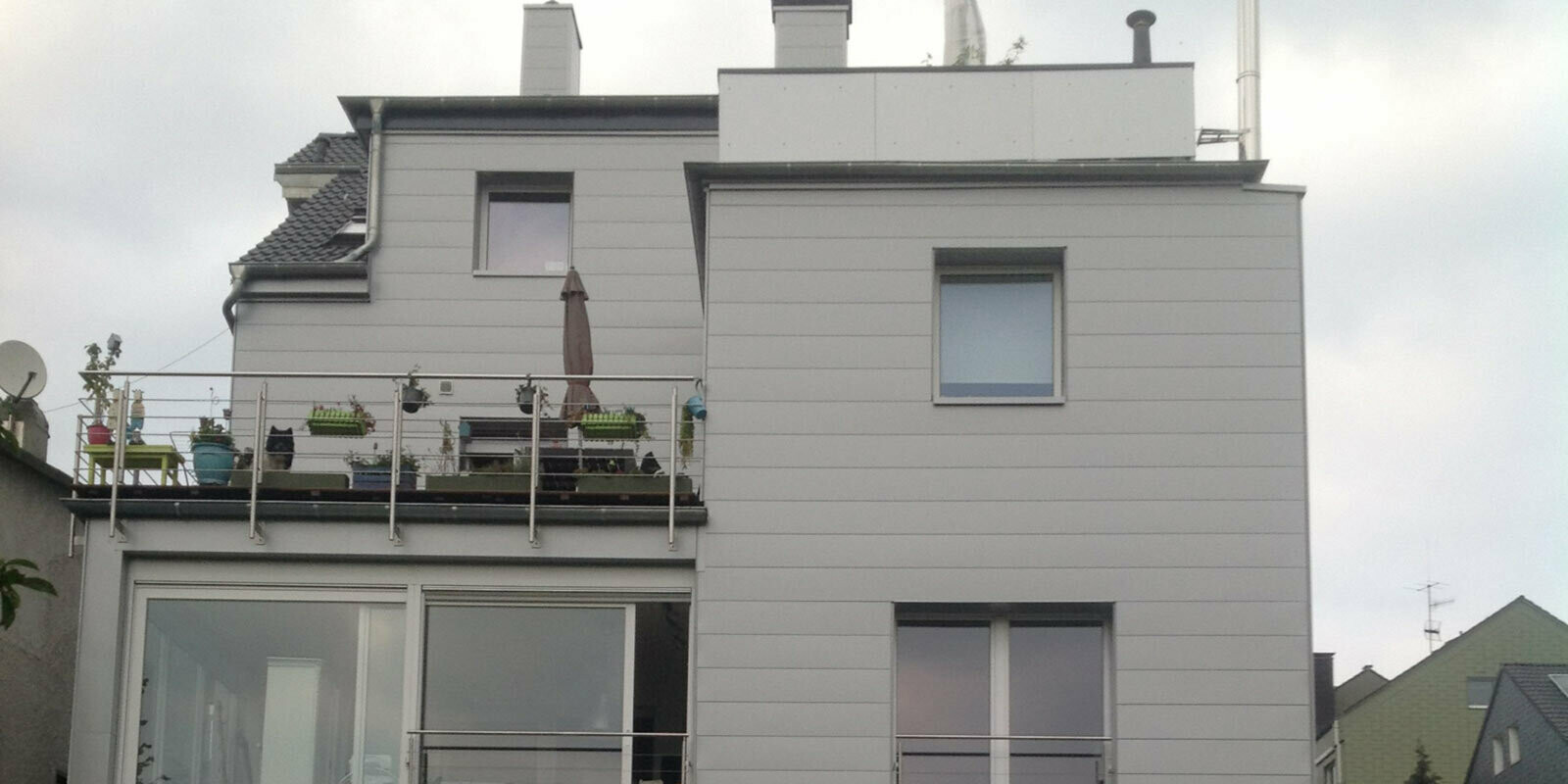 Condominio con tetto piatto e terrazzo con la nuova facciata ristrutturata con doghe di rivestimento PREFA