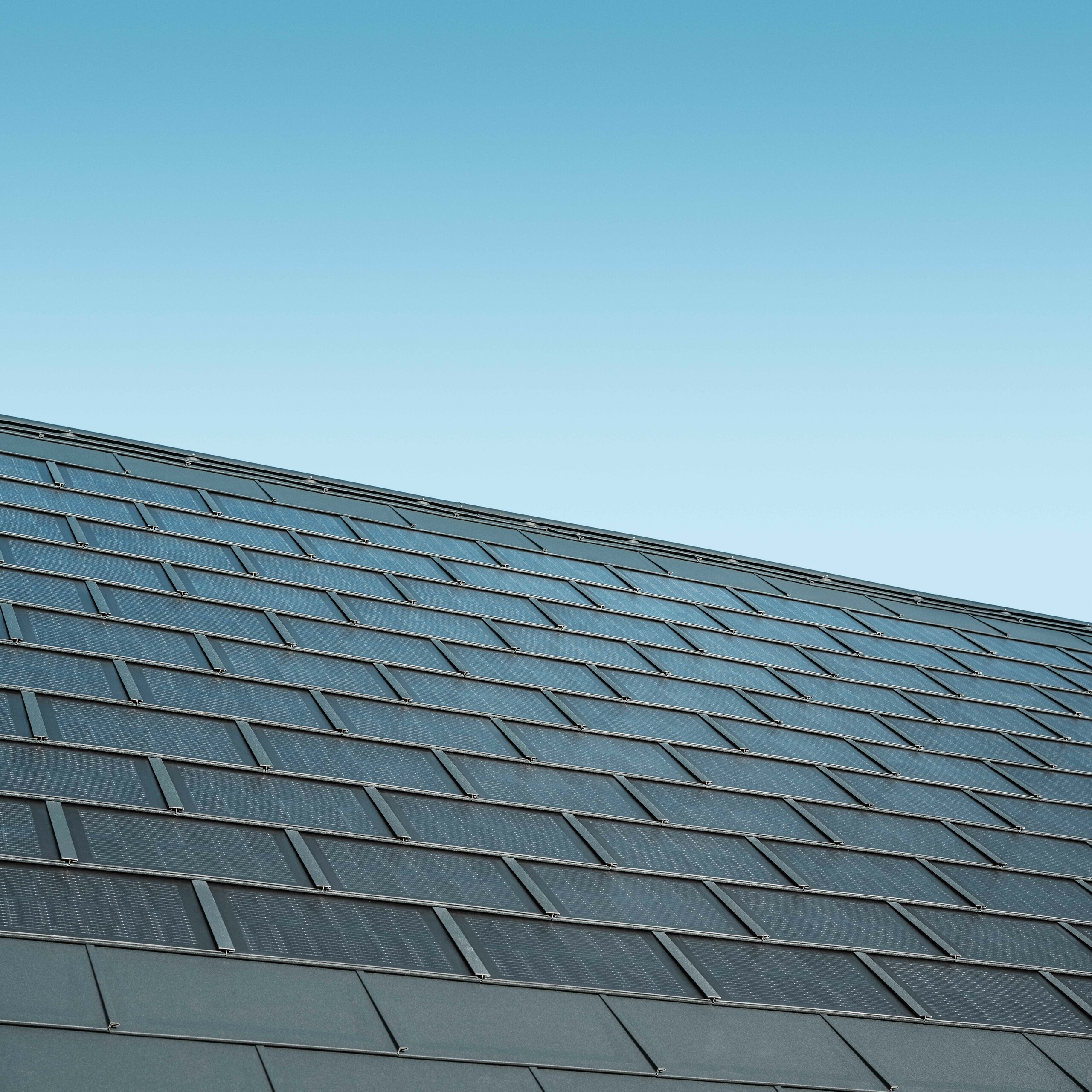 Photo d'une surface recouverte de tuiles solaires couleur anthracite, combinées au R.16