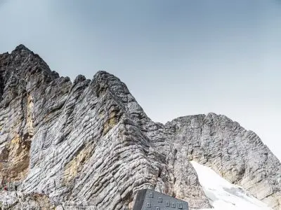 Il rifugio Seethalerhütte a 2.740 metri nel cuore del paesaggio roccioso del monte Dachstein, rivestito in copertura e facciata con i pannelli FX.12 PREFA P.10 grigio pietra