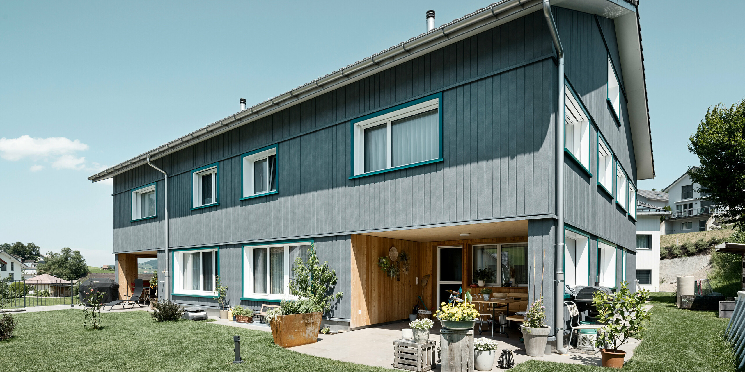 PREFA Sidings in P.10 Steingrau bzw. P.10 Prefaweiß an den Fassaden von zwei benachbarten Mehrfamilienhäusern in Weissbad, Schweiz.