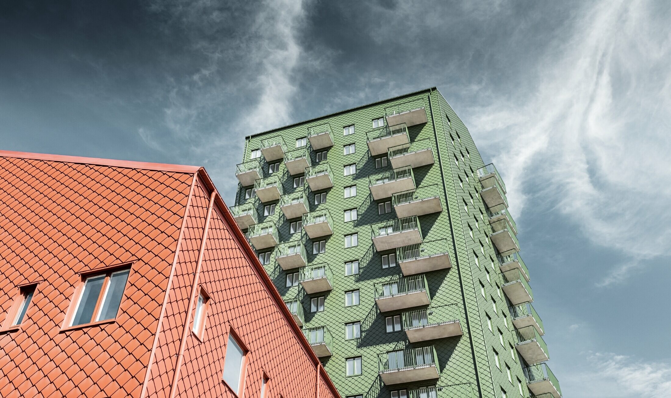 Edifici con balconi e design della facciata con scaglie PREFA 29 × 29 in verde oliva e rosso cotto