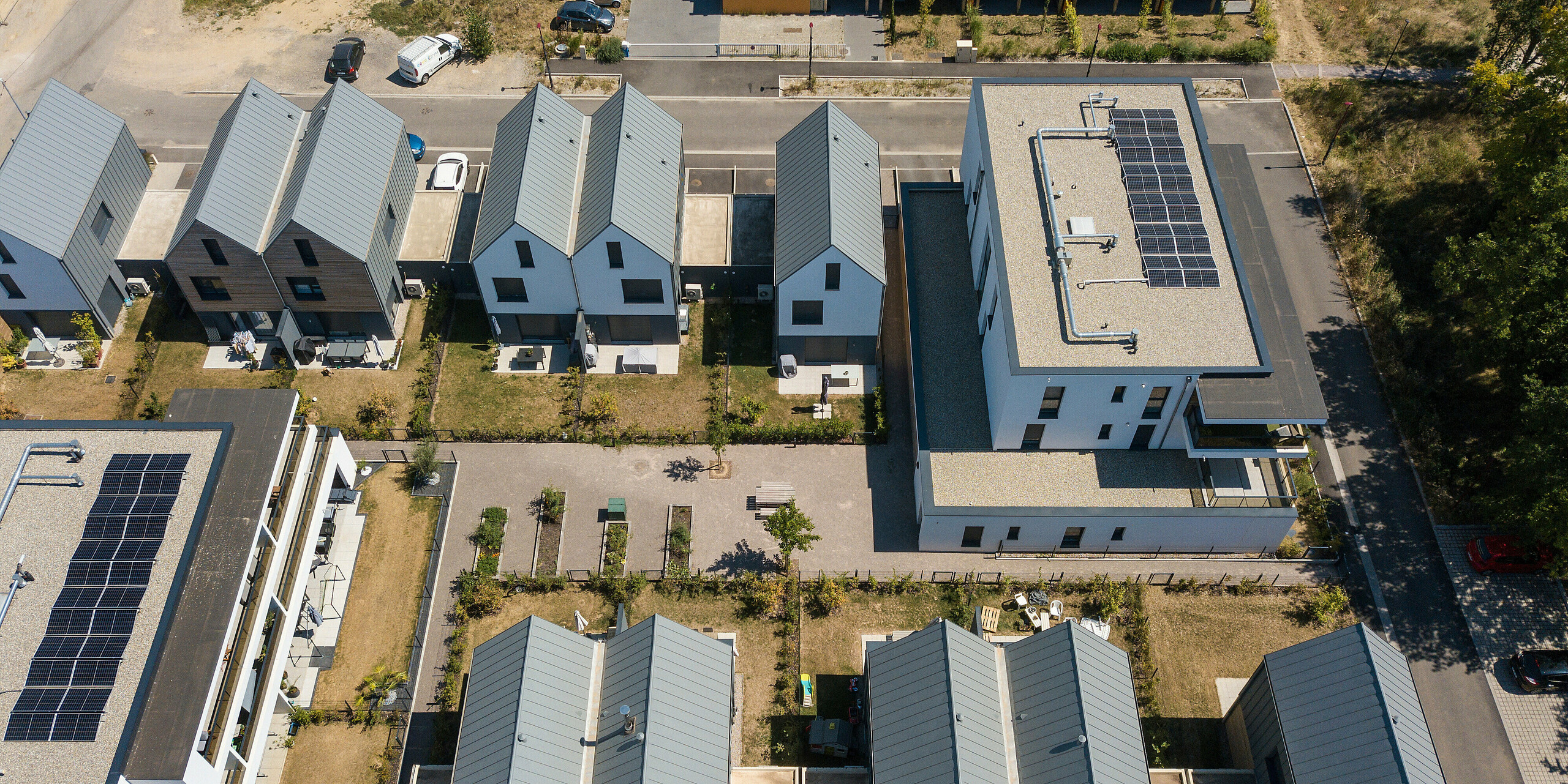 Le joint debout PREFALZ en gris souris s'étend sur les façades et les toits à pignon d'un lotissement mitoyen à Mundolsheim. Les coques uniformes du bâtiment en aluminium créent une image globale harmonieuse.