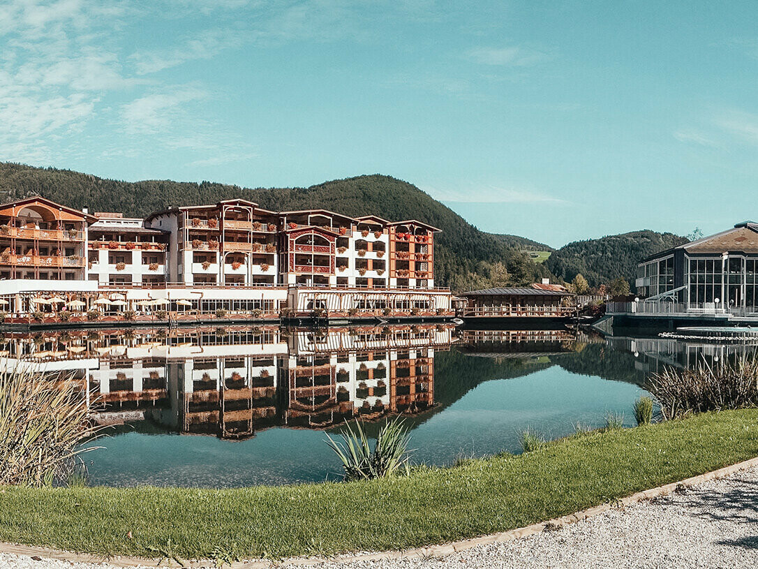 Photo de l'hôtel dans le paysage du Tyrol, devant l'hôtel se trouve le lac.