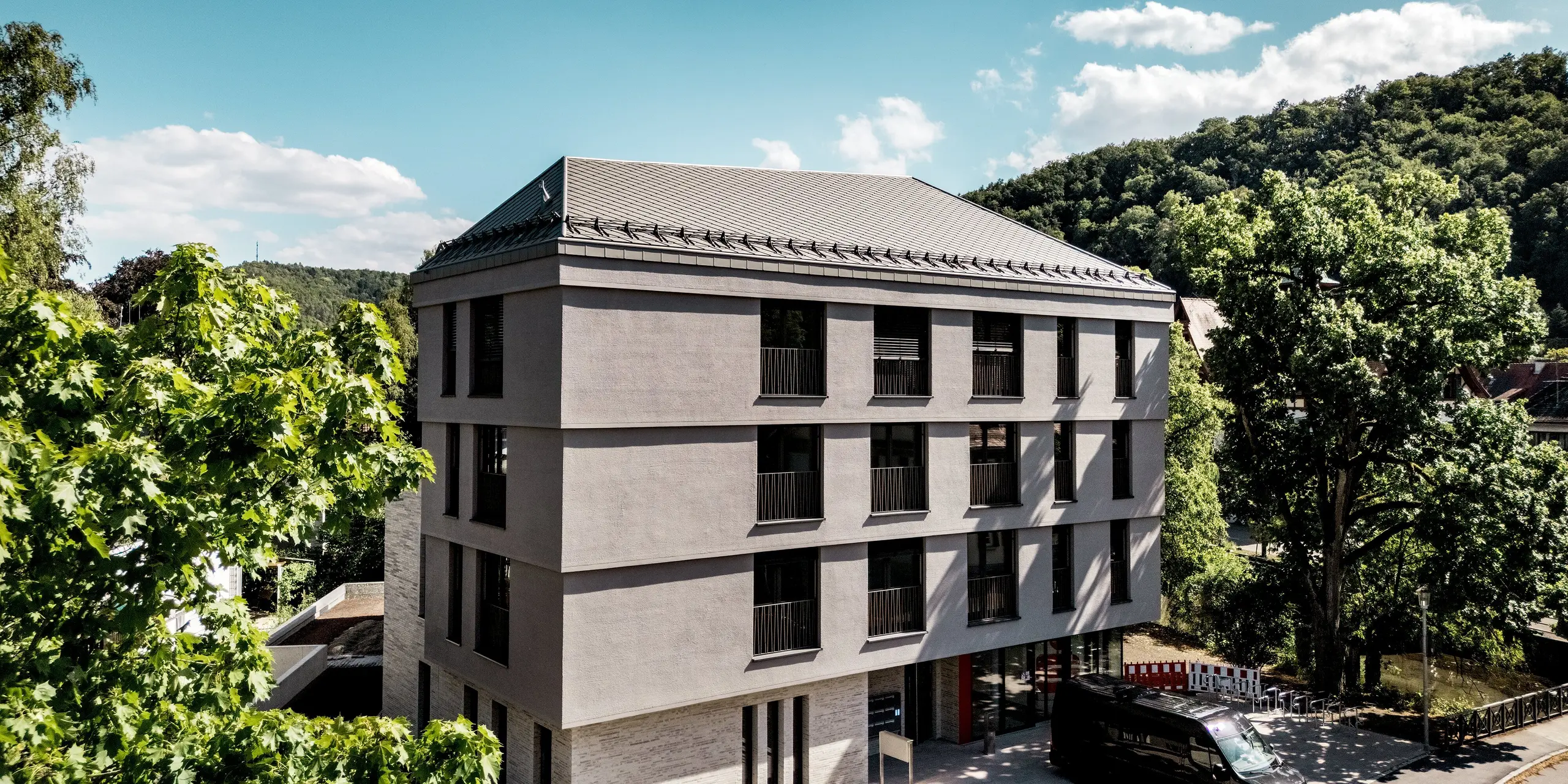 Die Sparkasse Blaubeuren präsentiert sich mit einer klaren, modernen Architektur und einem eleganten Dach aus PREFA Dachrauten 44 × 44 in Bronze. Die präzise Rautenstruktur und das markante Schneefangsystem unterstreichen die harmonische Dachgestaltung. Die leichten, langlebigen und witterungsbeständigen Aluminiumrauten verbinden zeitlose Ästhetik mit zuverlässigem Schutz und hoher Funktionalität.