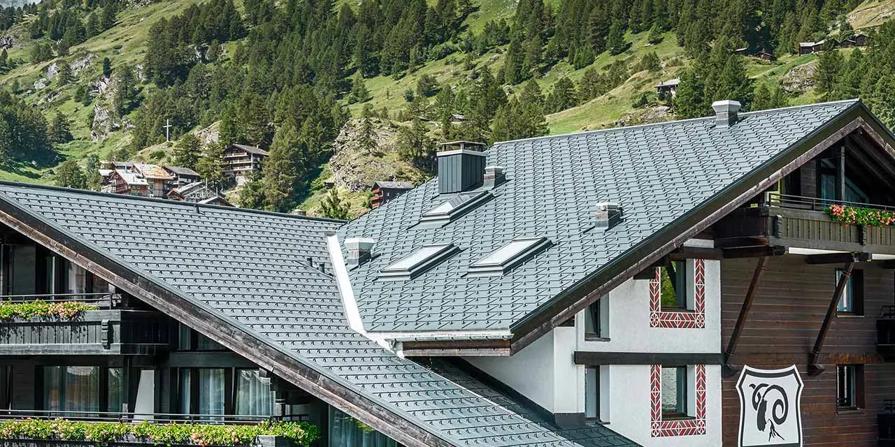 Hotelalpenhof a Zermatt con il Monte Cervino sullo sfondo, balconi, facciata in legno scura e una coperura in alluminio PREFA in antracite