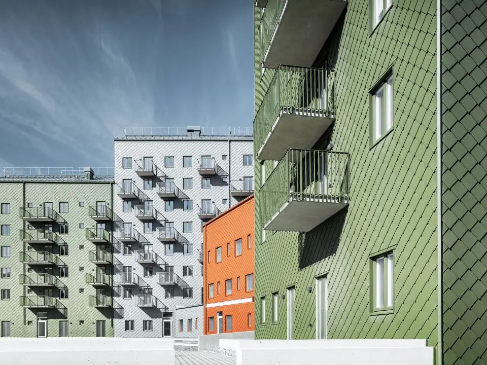 Die vier Wohnhäuser in Göteborg wurden mit PREFA Wandrauten in den Farben Olivgrün, P.10 Ziegelrot und Hellgrau eingedeckt 