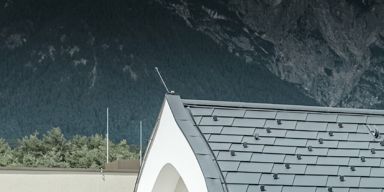 Vue détaillée d’une lucarne en ogive, habillée avec le bardeau de toiture PREFA couleur anthracite ; la lucarne est ici réalisée avec une toiture en ogive.