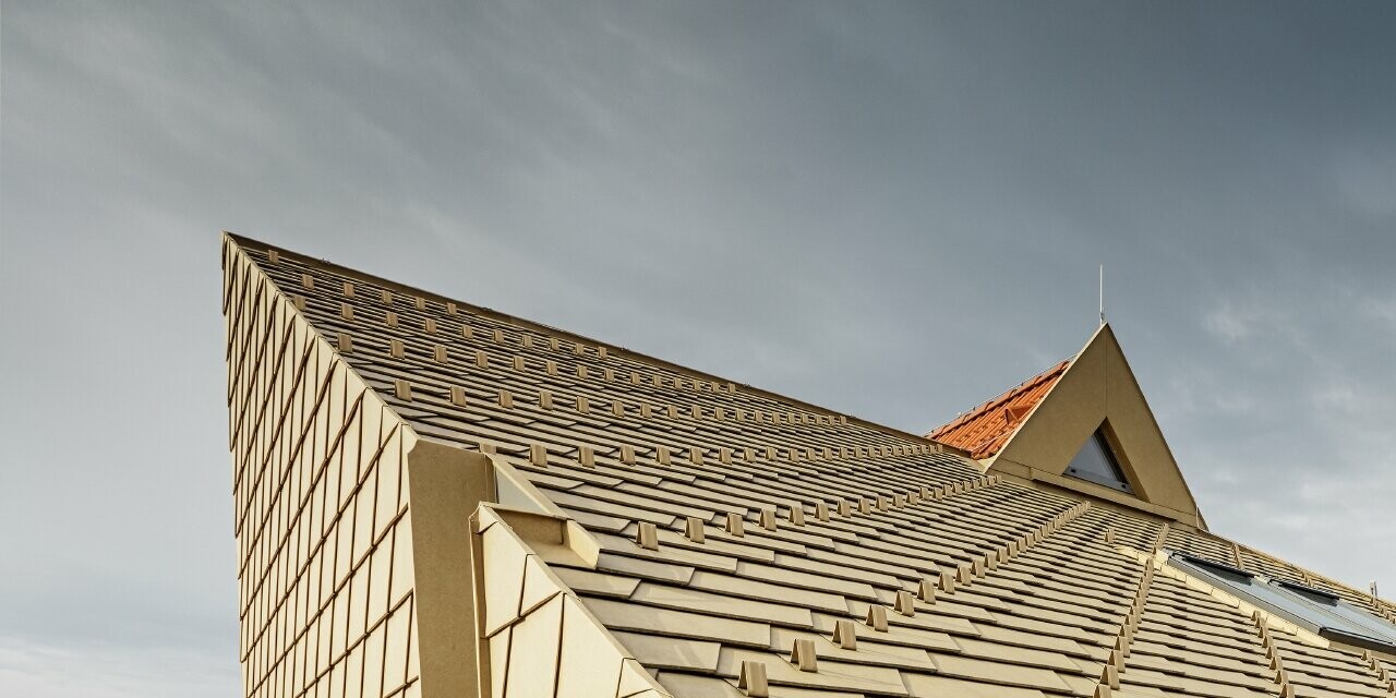 Ampliamento della casa senza sporto del tetto con grondaia a filo; le scandole PREFA sono state posate in marrone sahara