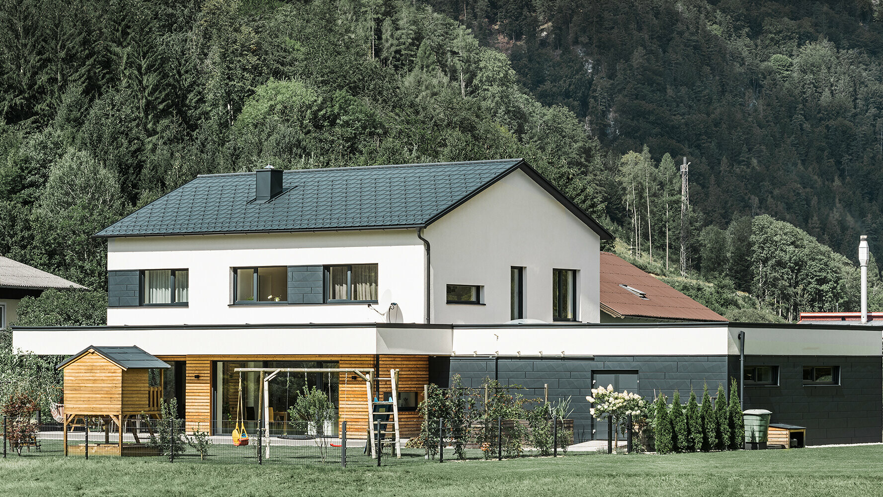 Einfamilienhaus Neubau mit Lärchenholz-Fassade in Kombination mit PREFA Siding.X in Anthrazit.