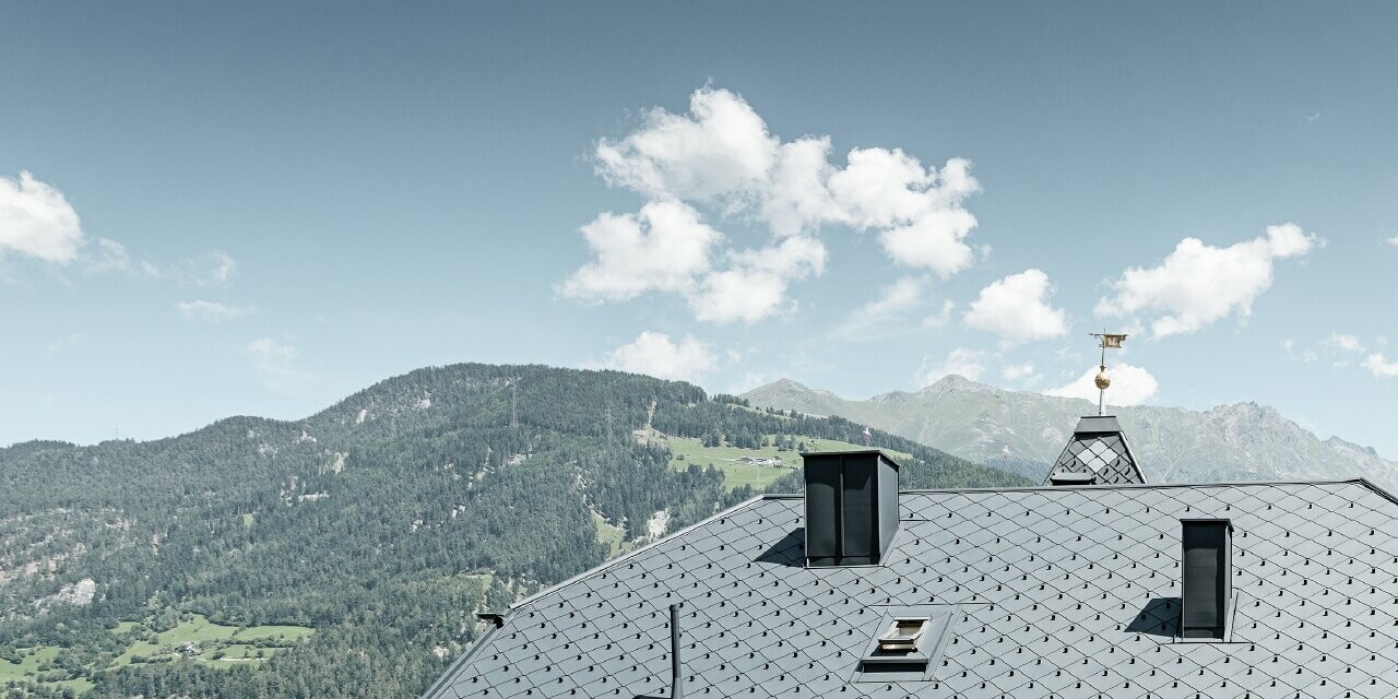 Villa flanquée d’une tour et hébergeant une pizzéria au rez-de-chaussée — Toiture en aluminium PREFA de couleur anthracite