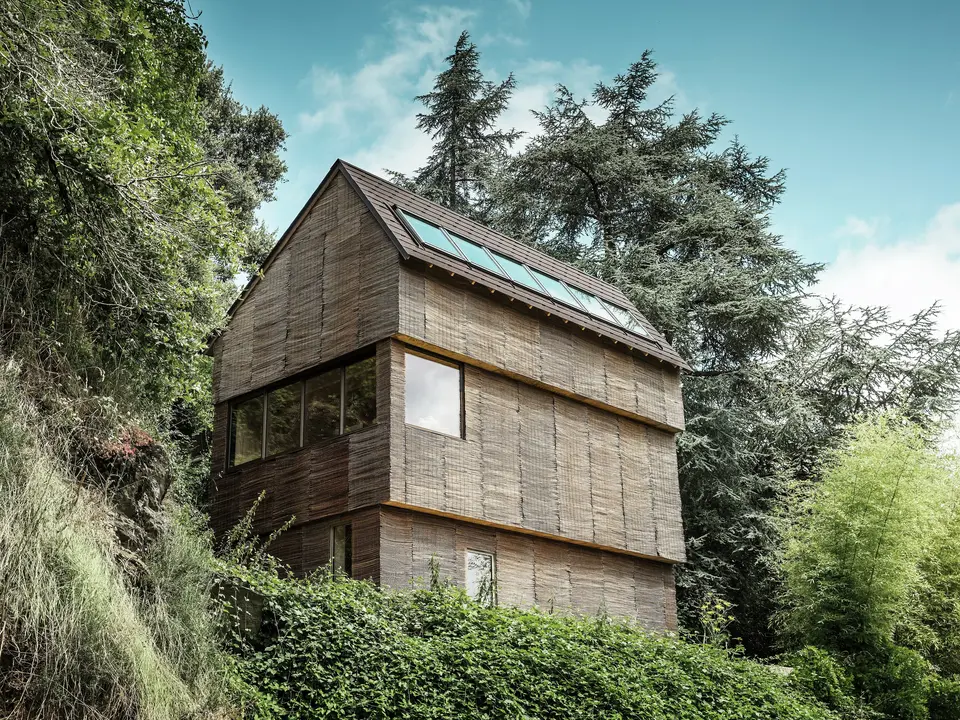 Casa nell'ovest della Francia con scandole PREFA in P.10 testa di morosu una collina scoscesa - design moderno con facciata in salice e tetto ad alta efficienza energetica.
