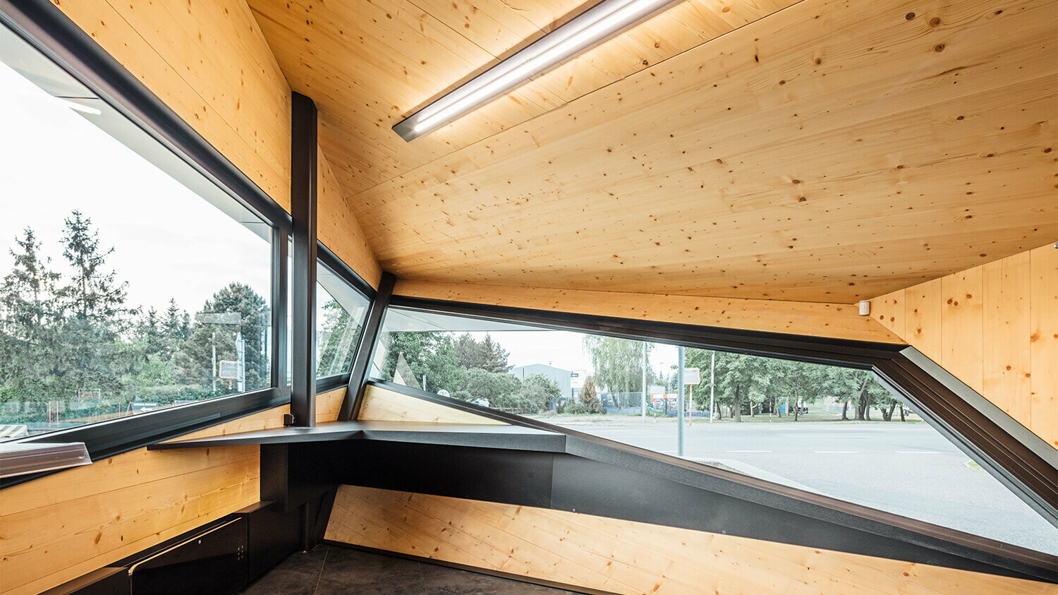 Innenaufnahme der Tankstelle mit einer Holzbekleidung, die Fenster ermöglichen einen weitreichenden Blick über das Geschehen vor Ort.