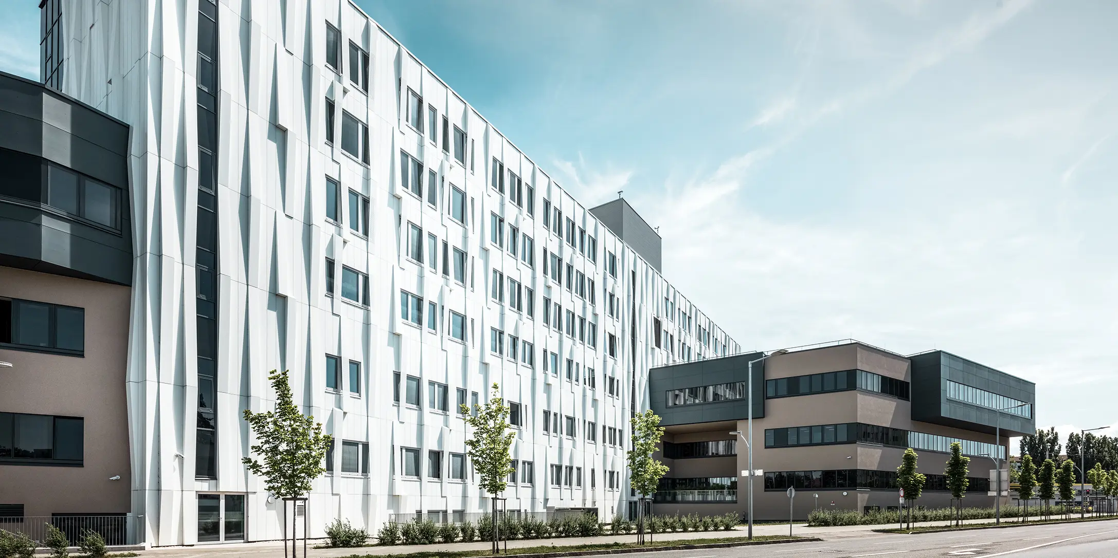 Entrée de la gare routière de Lenti ; la sous-face de la toiture est revêtue de panneaux composites en aluminium PREFABOND de PREFA en blanc pur, tandis que les éléments de façade au niveau des portes d'entrée et des vitrines sont revêtus de P.10 anthracite.