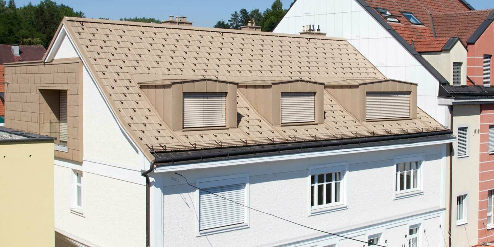 Ristrutturazione del tetto con pannelli FX.12 PREFA marrone sahara e tre abbaini