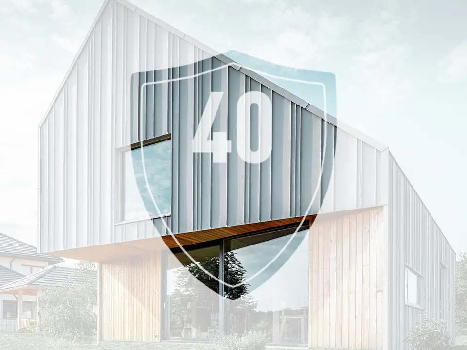 L'immagine mostra un cartello con il numero “40”, che rappresenta la garanzia sui prodotti in alluminio PREFA, davanti a una moderna casa unifamiliare.