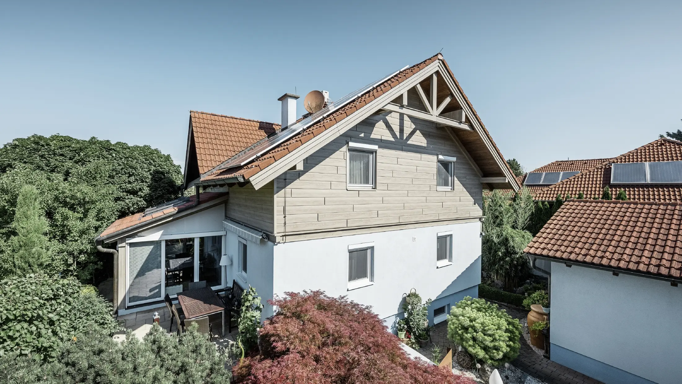 Frisch sanierte Fassade mit hinterlüfteter Alufassade im Obergeschoß; Der Giebel wurde mit Sidings in Holzoptik (Eiche beige-grau) verkleidet. 