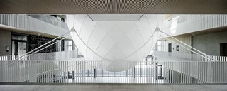 Vue de face de la glace flottante en acier et aluminium avec une coque Prefalz en P.10 Prefa blanc dans l'entrée de l'université.