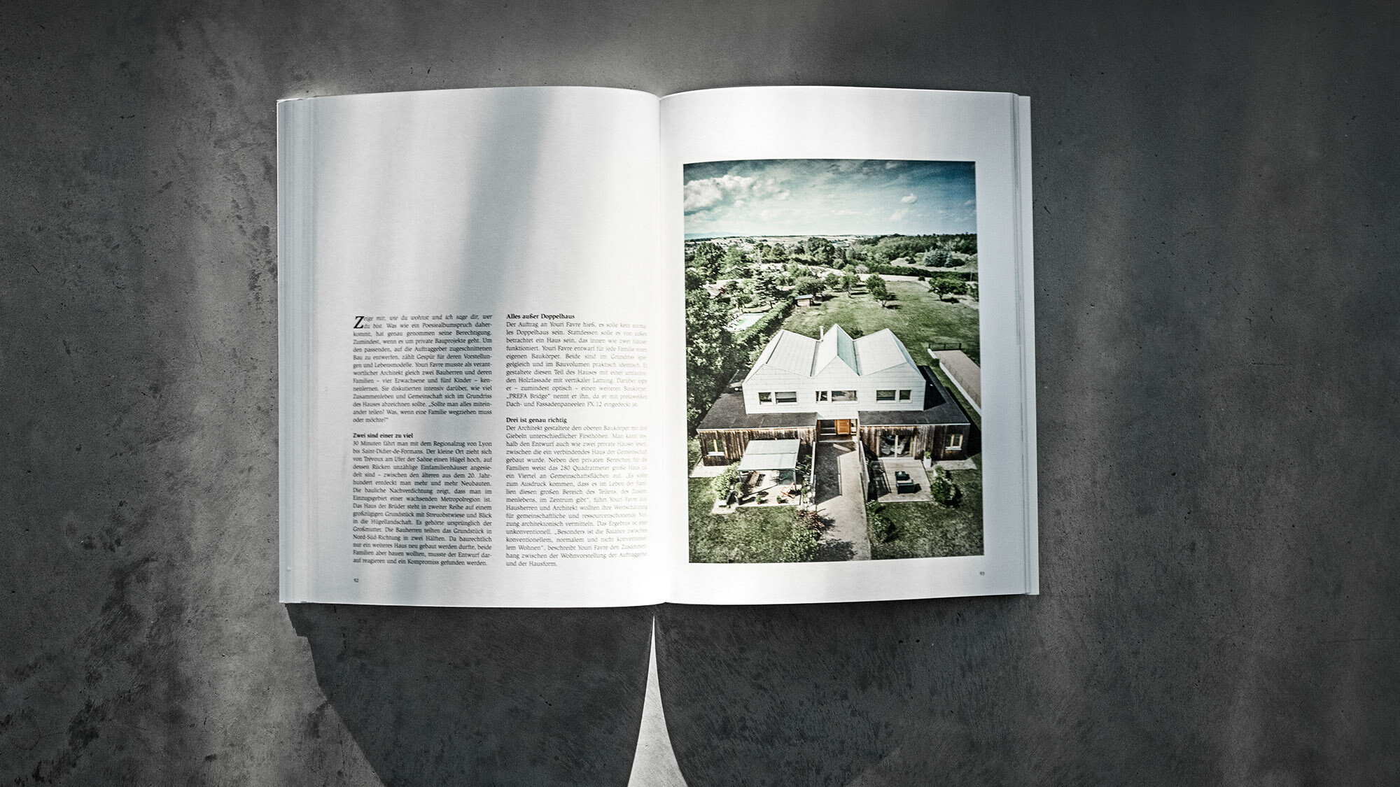 Le livre PREFARENZEN 2024 ouvert et sur fond gris avec un article sur la maison double par Youri Favre Architecture.