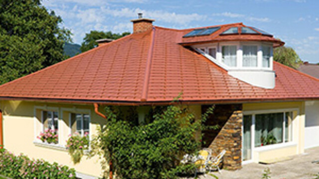 Einfamilienhaus mit Walmdach und einer Aluminium Dacheindeckung in Ziegelrot