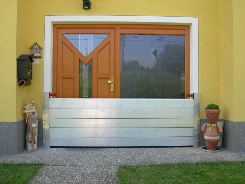 Porte d’une maison individuelle avec le système moderne de protection contre les crues de PREFA 
