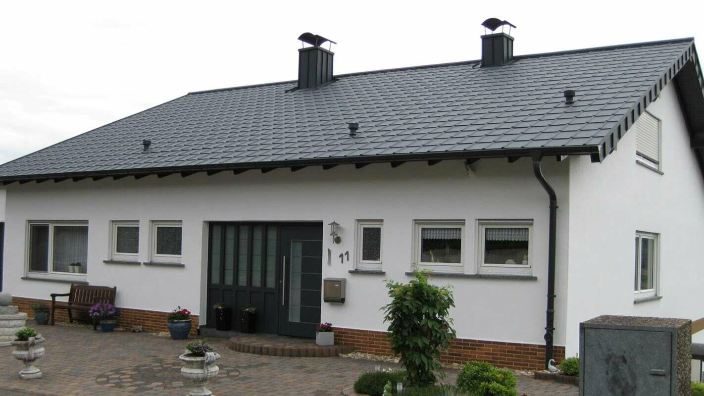 Einfamilienhaus mit einfachem Satteldach nach der Dachsanierung mit der PREFA Dachplatte