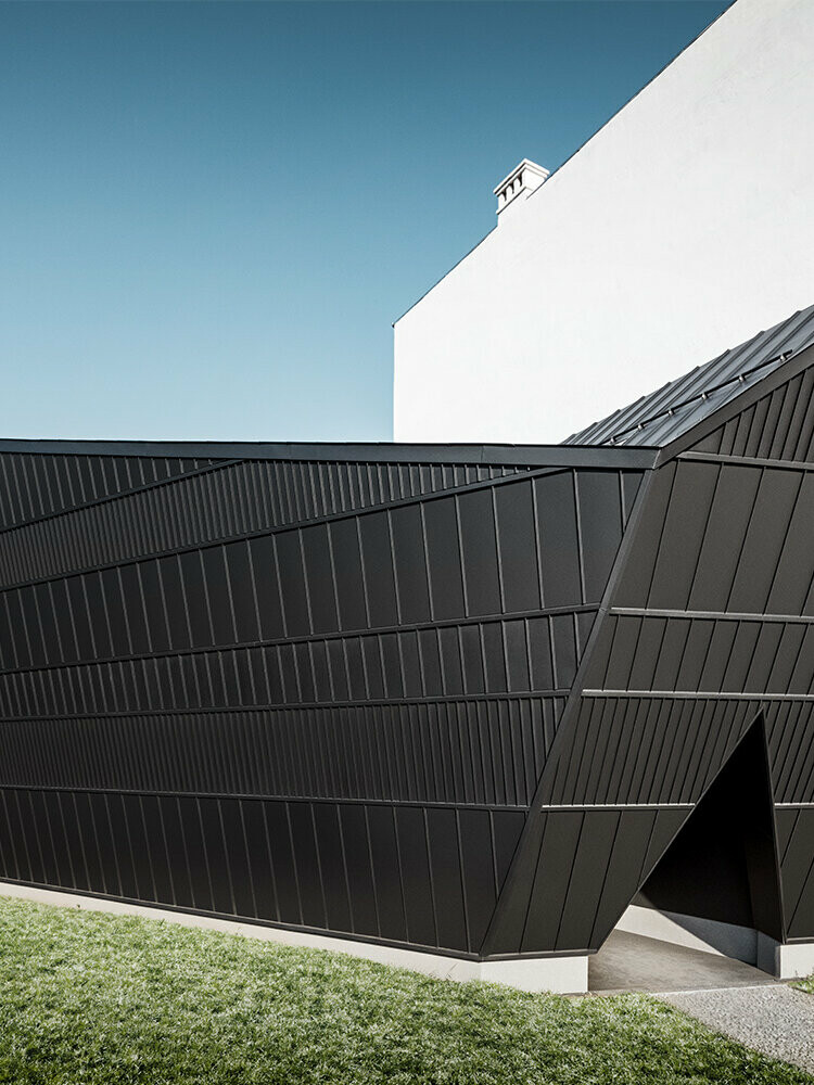 Der neue, mit schwarzem Aluminium ummantelte Kinopavillon des Museums in Skanzen von einer seitlichen Perspektive, entworfen vom Architekten István Bársony.
