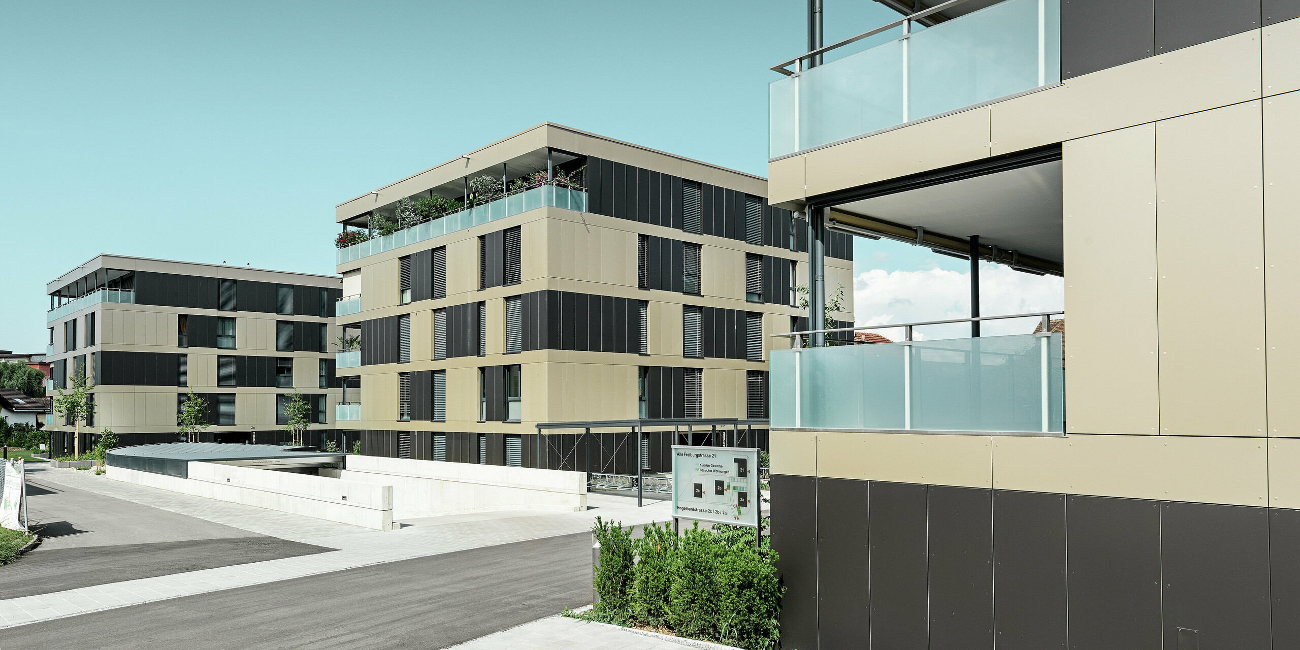 Die moderne Wohnanlage in Murten (CH) beeindruckt mit einer PREFA Fassade, die mit Aluminium Verbundplatten in den Farben Bronze und Schwarzgrau ausgestattet wurde. Diese Kombination sorgt für ein zeitloses und elegantes Erscheinungsbild. Die langlebigen Platten bieten nicht nur ästhetische Vorteile, sondern auch einen hervorragenden Witterungsschutz, der die Fassade funktionell und attraktiv macht.