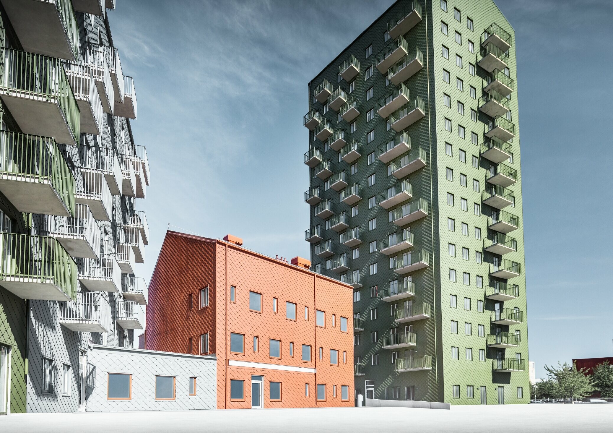 Mehrere Wohnbauten verkleidet mit der PREFA Wandraute 29 × 29 in den Farben Olivgrün, Ziegelrot und Hellgrau in Göteborg, Schweden.
