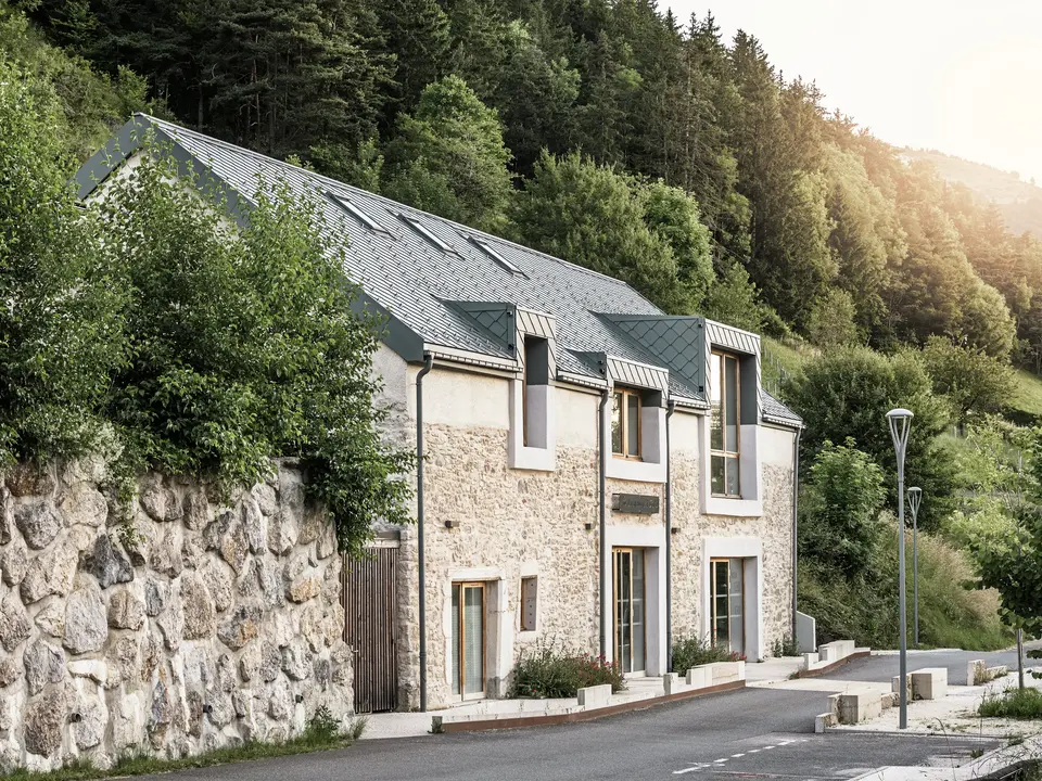 Il fienile restaurato “La Grange à Gaby” a Engins, in Francia. L'edificio combina la tradizionale muratura in pietra con un moderno tetto in alluminio PREFA composto da scaglie di 29 × 29 cm. La ristrutturazione combina metodi di costruzione storici con un'architettura contemporanea e materiali sostenibili che attirano l'attenzione.