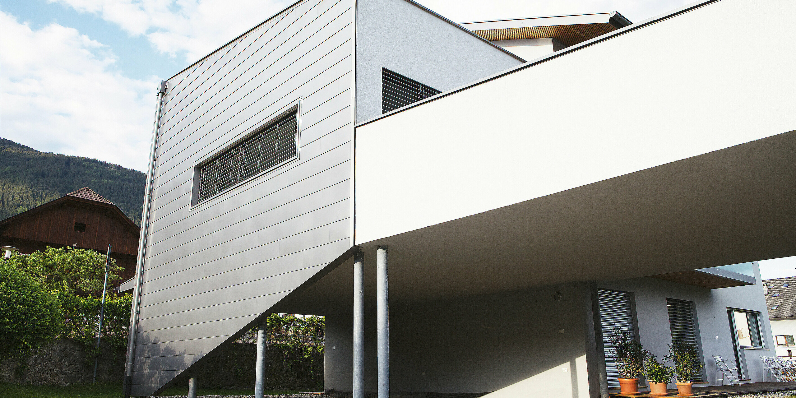 Die Rückansicht des Hauses in Pfalzen zeigt die durchgehende PREFALZ Fassadenbekleidung. Die langlebige PREFA Oberfläche trotzt Wind und Wetter und bleibt wartungsarm - ideal für anspruchsvolle Bauherren, die Wert auf Qualität und Design legen.