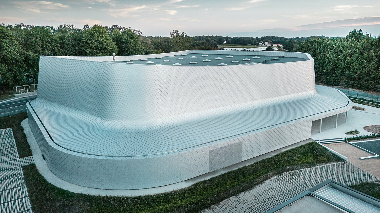 Prise de vue depuis le ciel du bâtiment avec son environnement et un aperçu de la couverture.