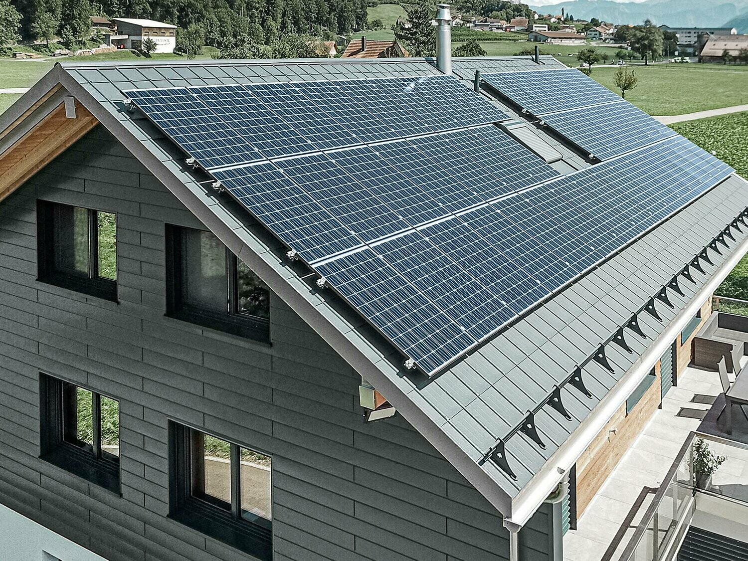 Centrale photovoltaïque installée sur toiture PREFA avec supports solaires et rail profilé assurant la sécurité de la fixation.