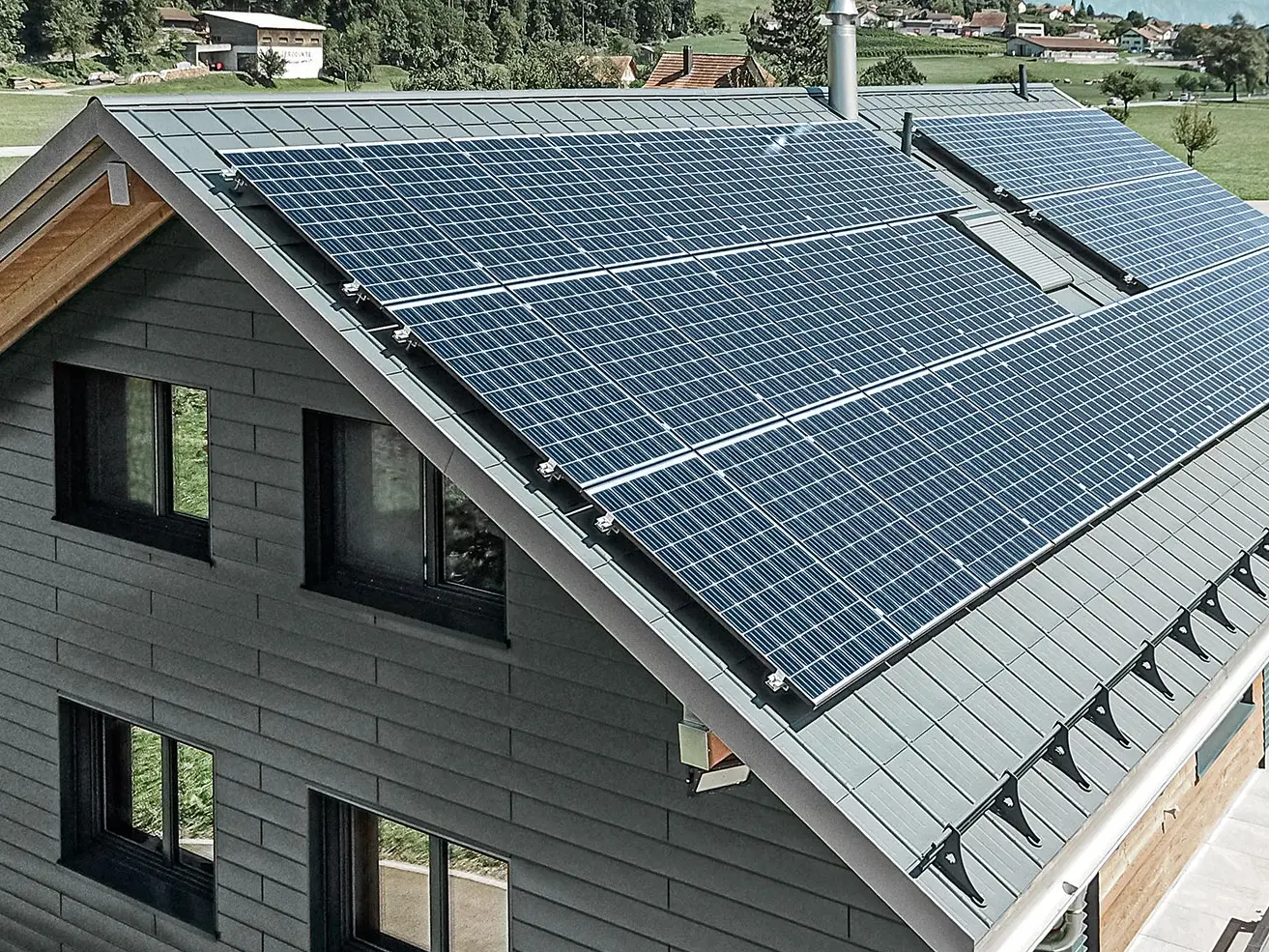Centrale photovoltaïque installée sur toiture PREFA avec supports solaires et rail profilé assurant la sécurité de la fixation.
