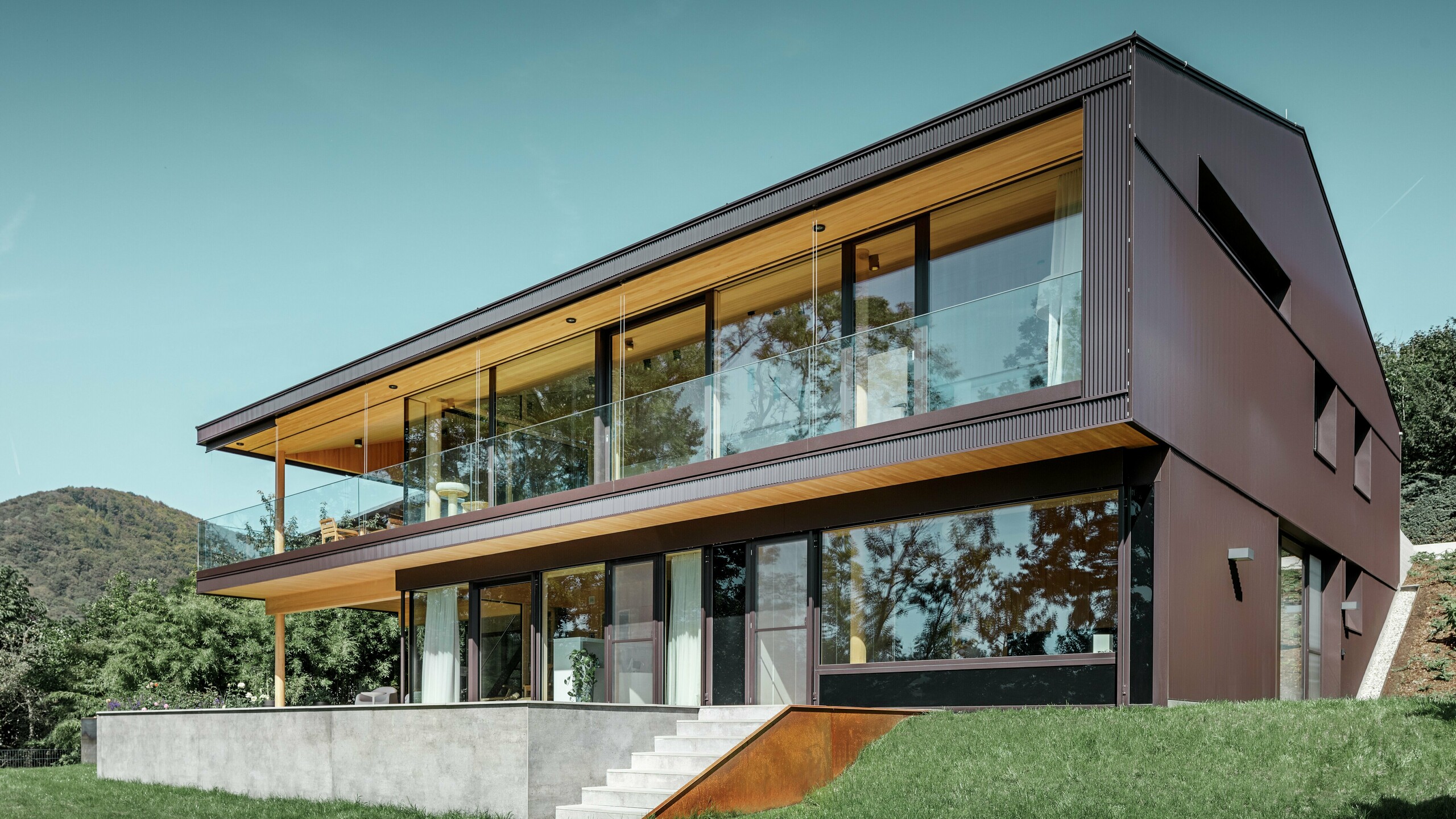 Dieses moderne Einfamilienhaus in Linz verfügt über eine großzügige Terrasse und große Fenster auf der Gartenseite. Die Fassade wurde mit PREFA Zackenprofil in Nussbraun verkleidet. Die einzigartige Fassade aus stranggepresstem Aluminium verändert ihr Erscheinungsbild je nach Lichteinfall und verleiht dem Objekt einen einzigartigen Look.