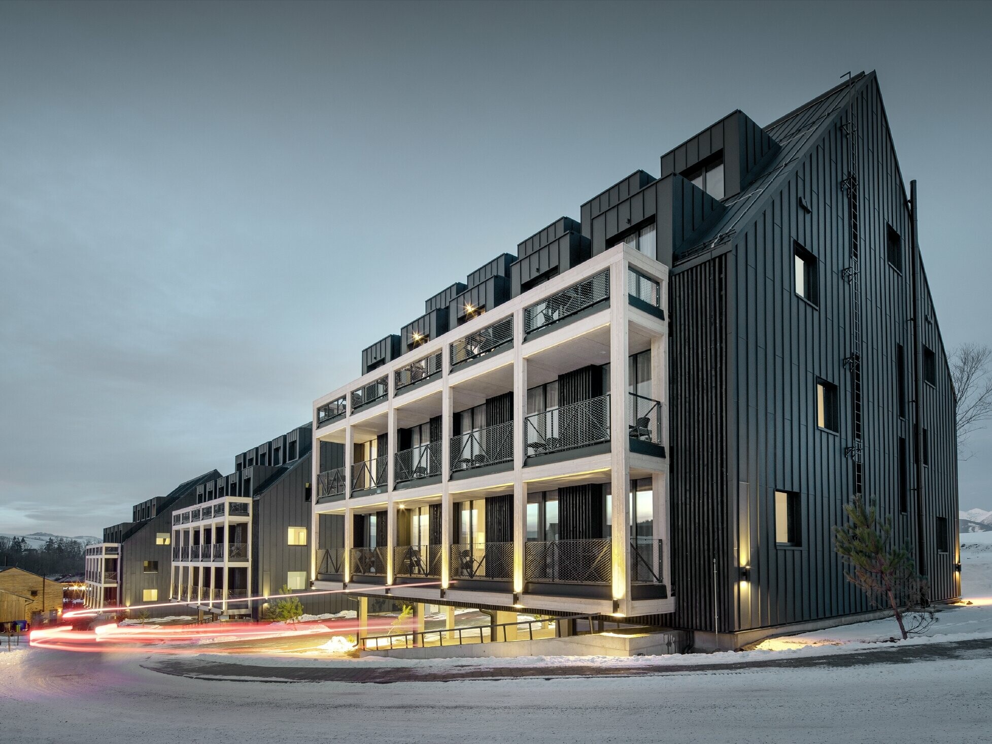 Bâtiments de station de ski en Slovaquie avec balcons et lucarnes, les façades sont habillées de Prefalz couleur anthracite, tout comme le toit à deux versants, environnement enneigé