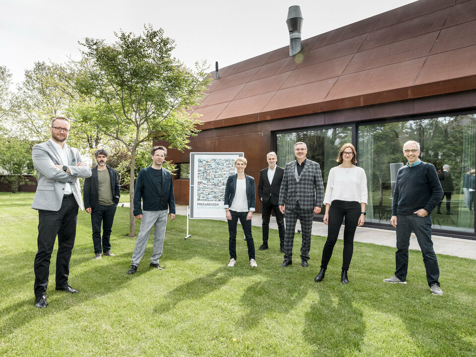 Die Teilnehmer des PREFARENZEN Dialogs 2024 auf der Wiese vor einem braunen Gebäude am Weingut Velich.