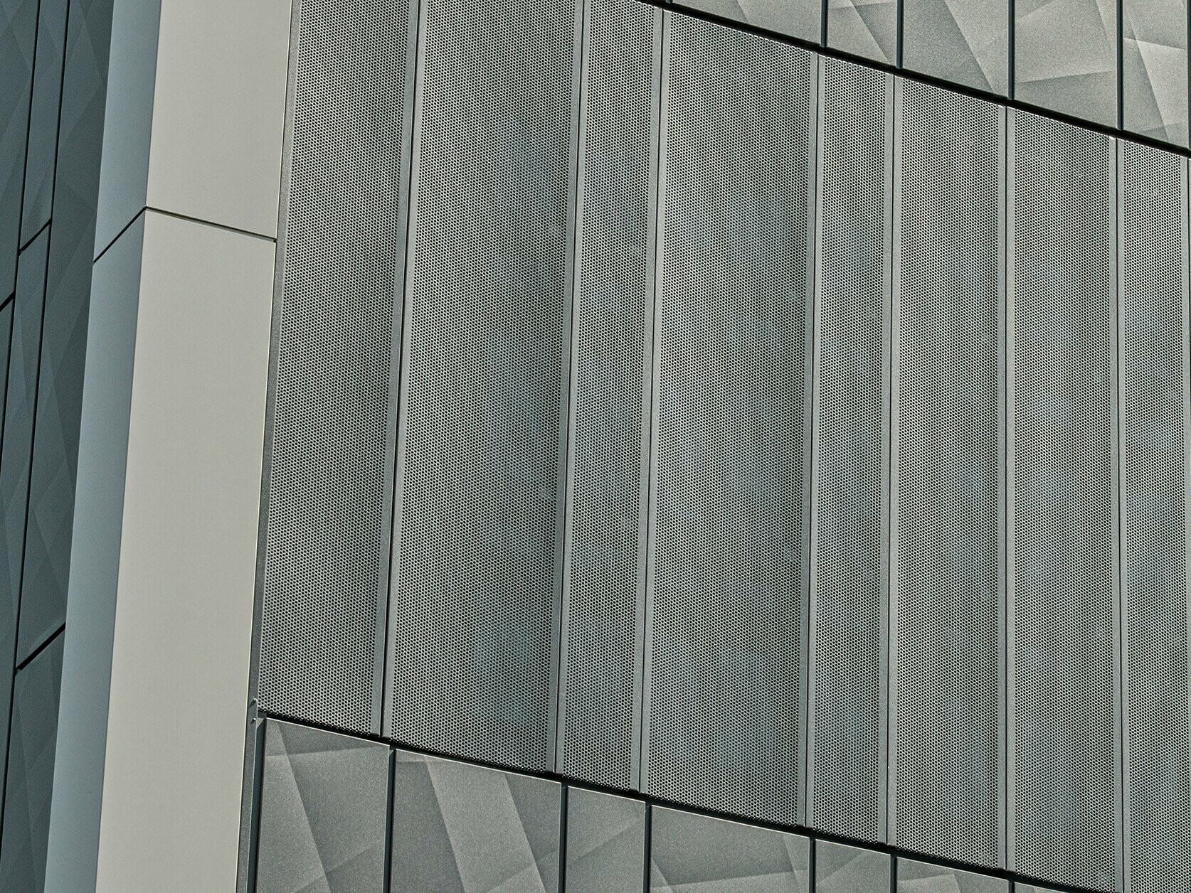 Fassadenansicht eines Eurospar-Markts in Rohrbach mit PREFA Siding.X und perforierten Sidings in der Farbe Anthrazit. Die Siding.X-Elemente zeigen ein lebendiges, geometrisches Fugenbild, während die perforierten Sidings eine moderne, luftdurchlässige Struktur bieten.