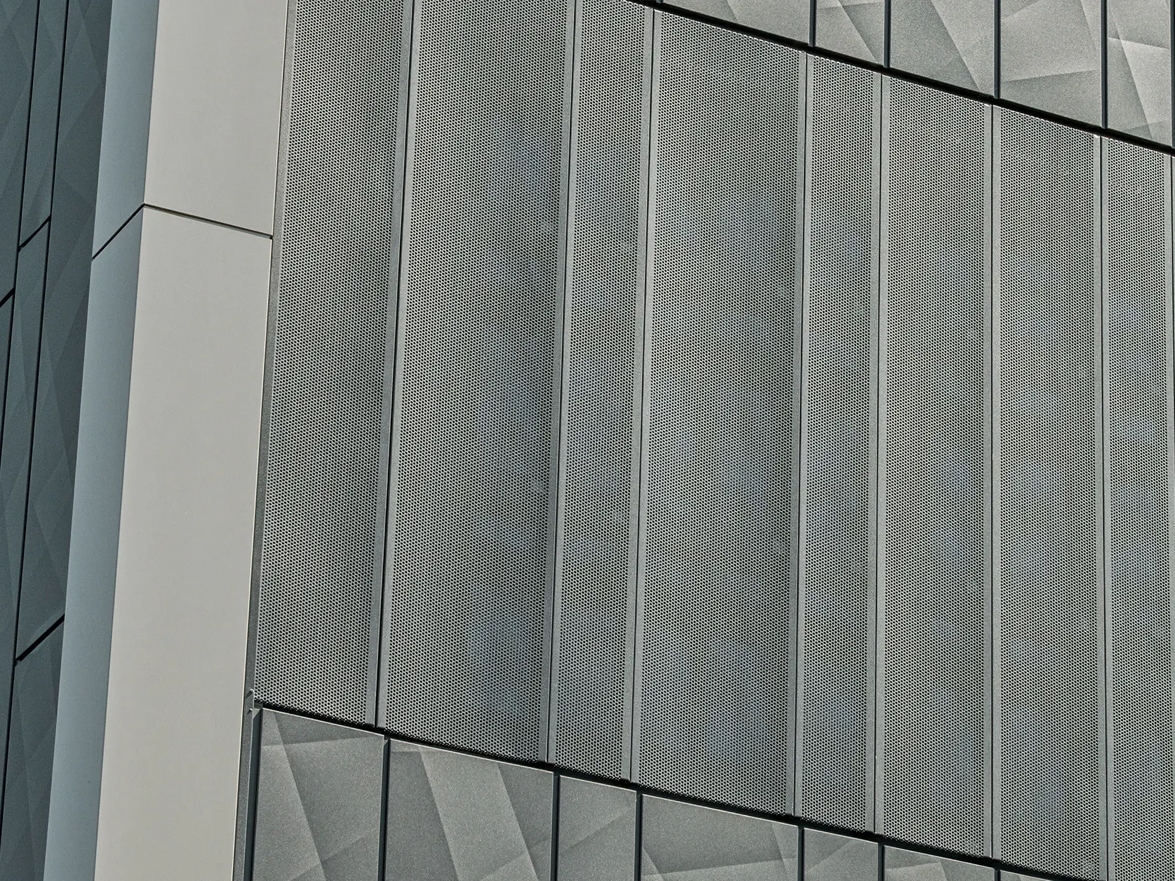 Fassadenansicht eines Eurospar-Markts in Rohrbach mit PREFA Siding.X und perforierten Sidings in der Farbe Anthrazit. Die Siding.X-Elemente zeigen ein lebendiges, geometrisches Fugenbild, während die perforierten Sidings eine moderne, luftdurchlässige Struktur bieten.