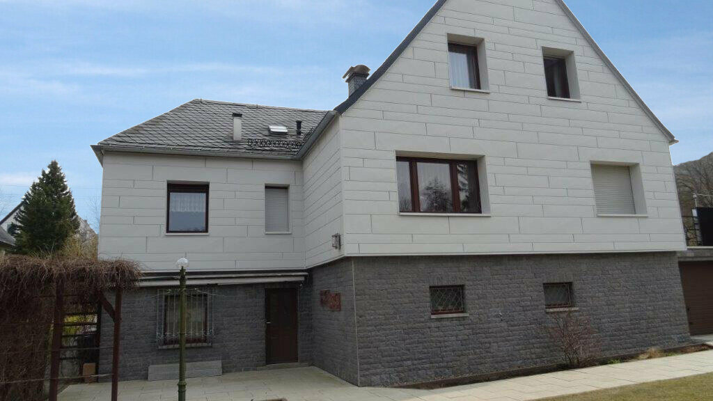 Fassadensanierung einer Putzfassade mit PREFA Sidings.X horizontal verlegt in Weiß mit grauem Klinker.